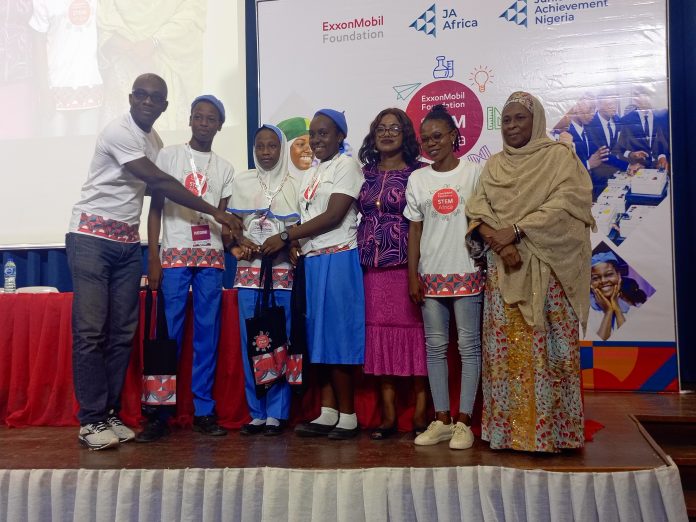 Presentation of the Award by Oge Udeagha, Africa Regional Communications Manager at ExxonMobil, to the winners of Africa's No. 1 STEM Quiz Competition. The recipients were Safiya Ibrahim, Ugaji Uneko, and Adebimpe Oluwapelumi, students of Government Secondary School Wuye, Abuja, accompanied by their Chemistry Teacher, Mrs. Nneji Nkechiyere.